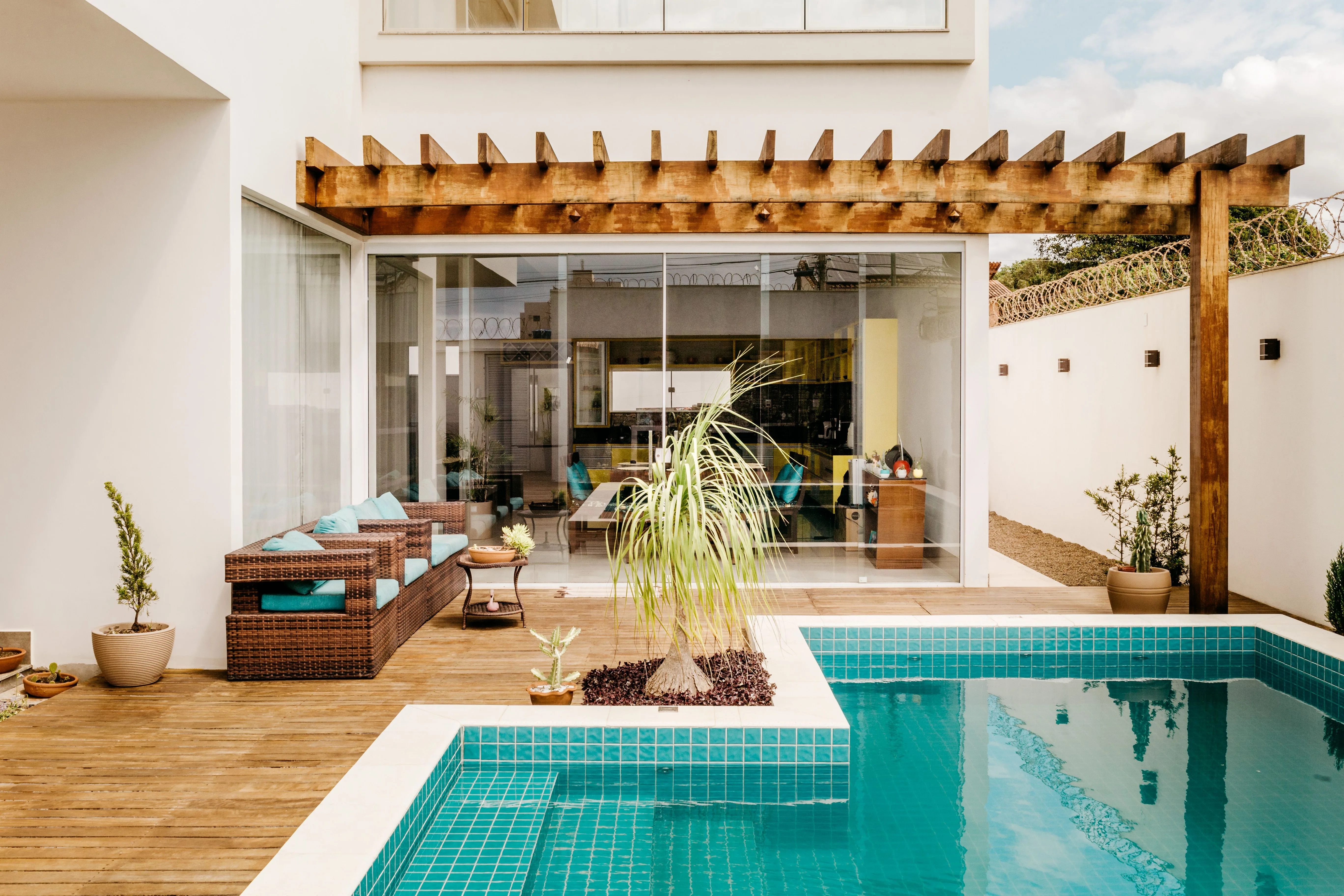 Terrace with a wooden pergola, outdoor lounge seating and a tiled plunge pool
